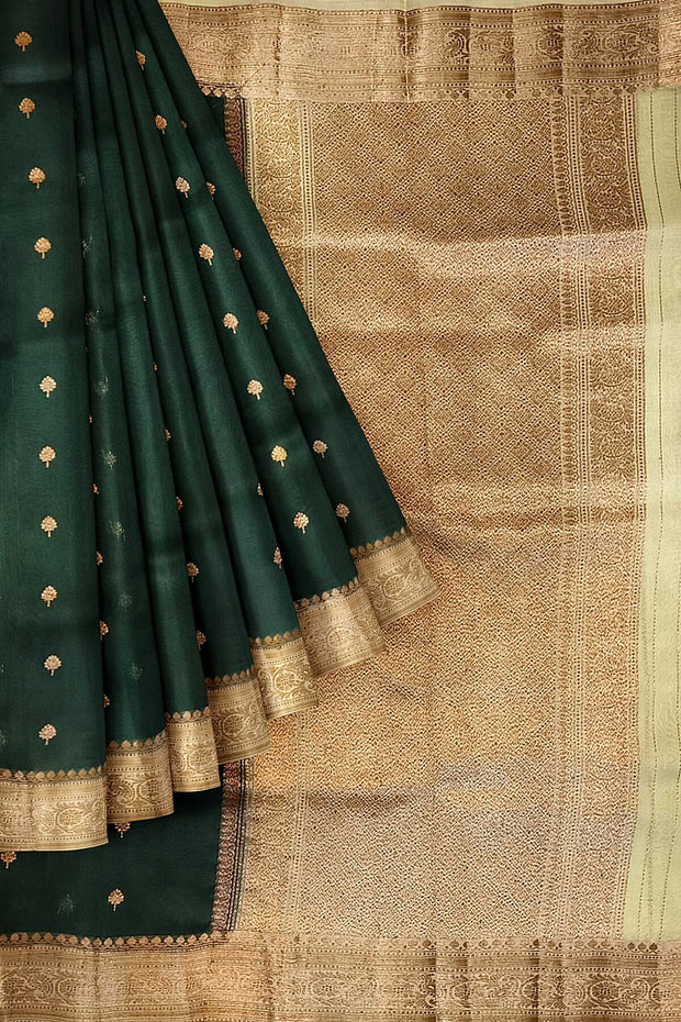 Banarasi kora ( organza) silk saree in bottle green with  gold motifs.