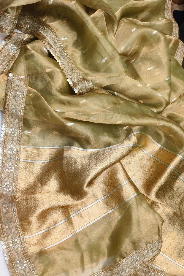 Green silk tissue handloom Banarasi saree with floral motifs and a lace border.