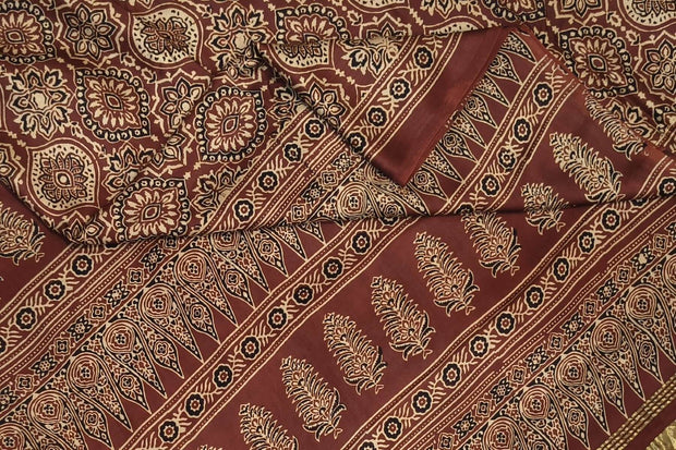 Modal silk saree in maroon with round motifs  in hand block ajrakh print and a tissue pallu