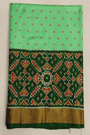 Handwoven Patola pure silk saree in green with small motifs and a skirt border