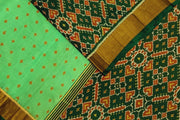 Handwoven Patola pure silk saree in green with small motifs and a skirt border