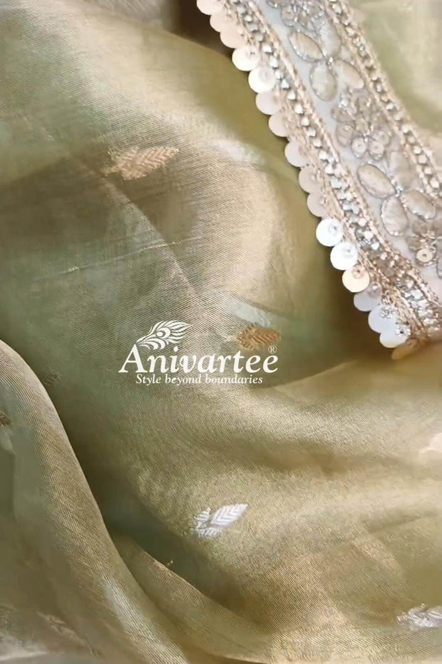 Green silk tissue handloom Banarasi saree with floral motifs and a lace border.